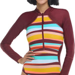 Woman wearing a colorful striped swimsuit with a maroon hood on a white background
