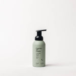 Guests of Earth Foaming Hand Soap in a matte sage green bottle with a black pump dispenser, centered against a clean white background.