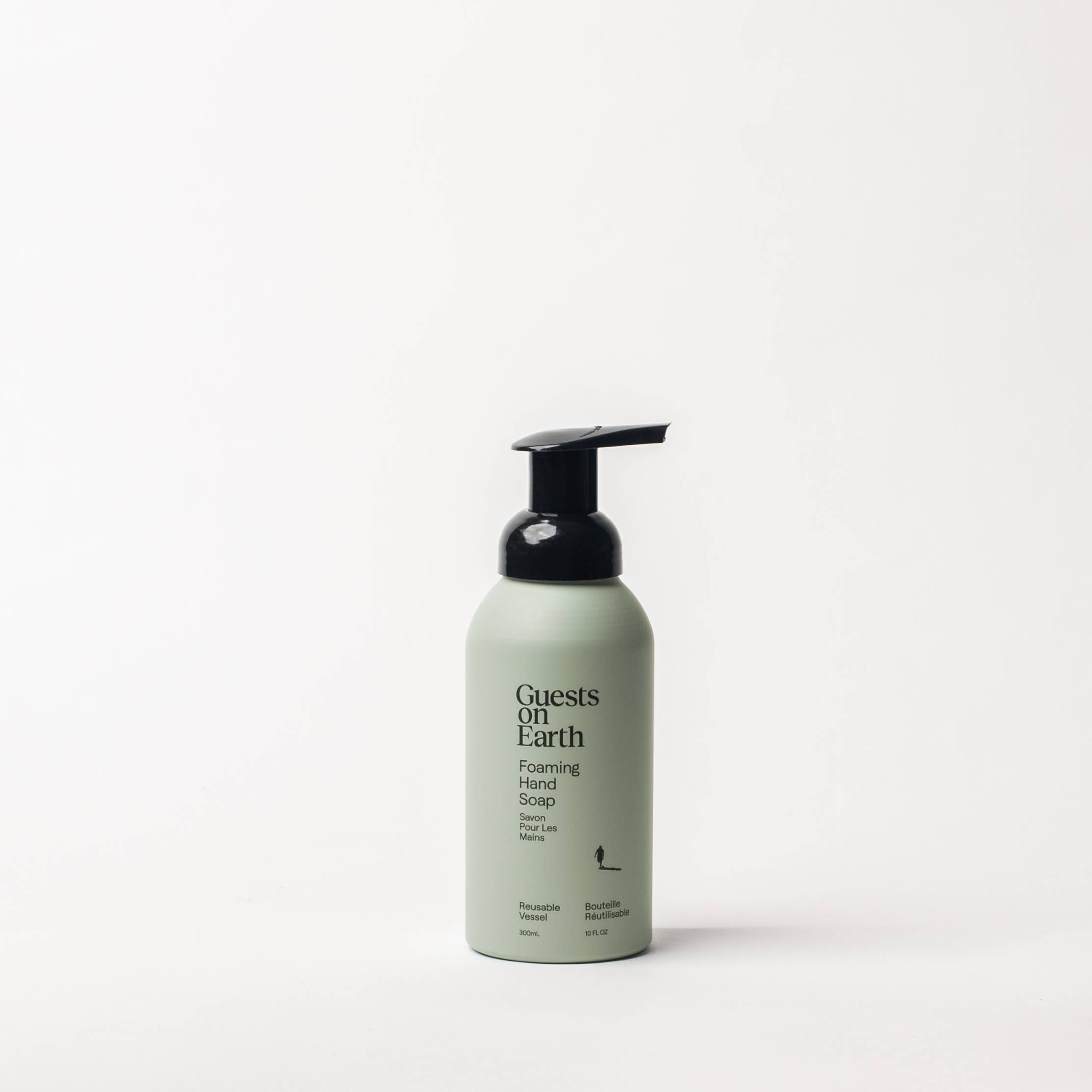 Guests of Earth Foaming Hand Soap in a matte sage green bottle with a black pump dispenser, centered against a clean white background.