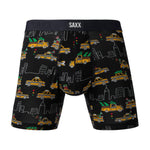 Black boxer briefs with taxi and cityscape pattern and SAXX branding on a gray background