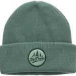A sage green ribbed knit beanie hat with a folded cuff, featuring a circular embroidered Tentree logo patch on the front.