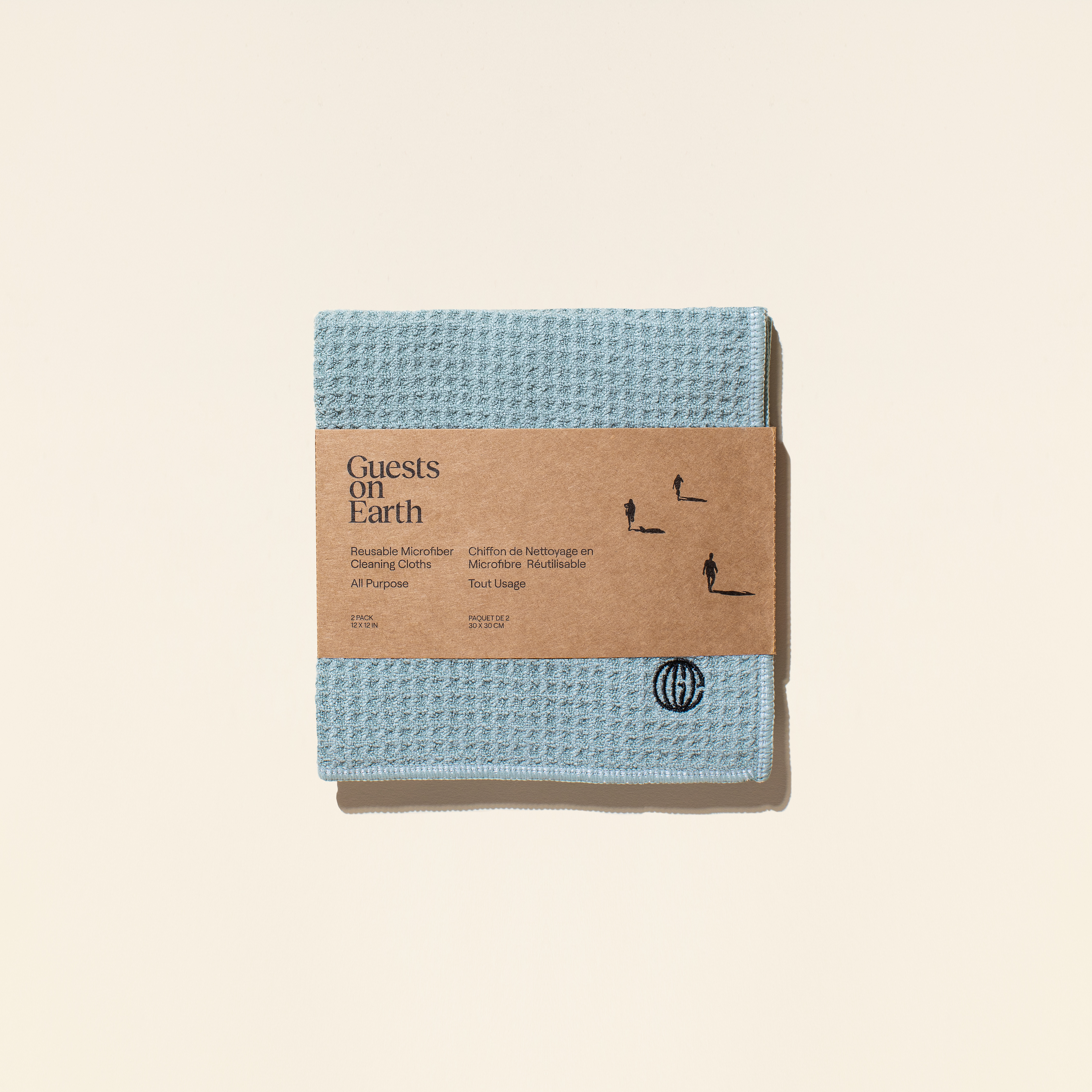 Blue microfiber cloth with cardboard packaging on a beige background