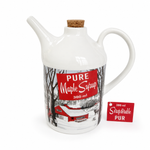 A white ceramic maple syrup pitcher with a cork stopper, featuring a vintage-style red label that reads 'PURE Maple Syrup 380 ml' with a winter scene. A small red tag reading '380 ml Straperable PUR' is placed beside it on a clean white background.